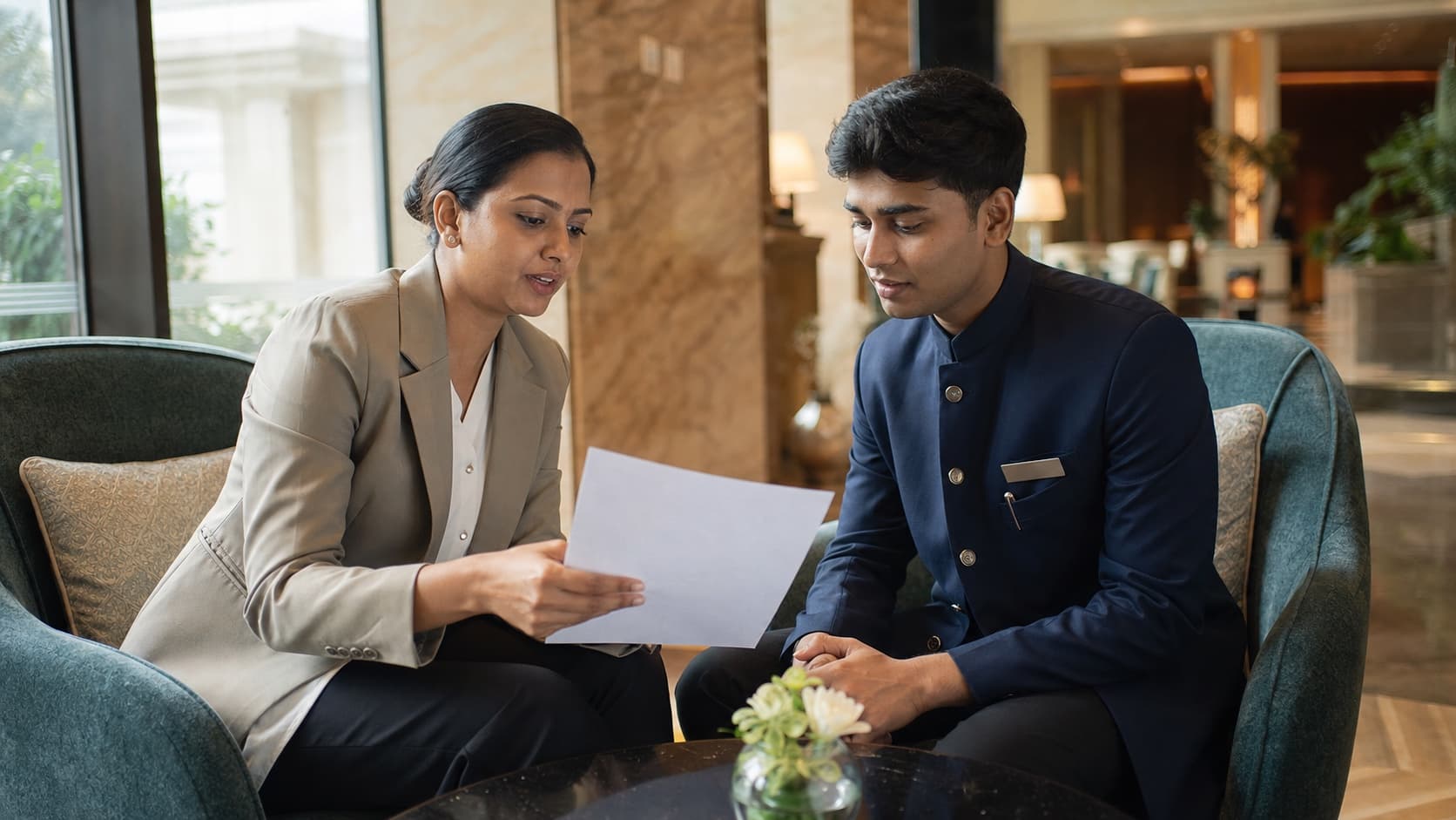 A hotel manager reviewing a work profile with a hospitality professional